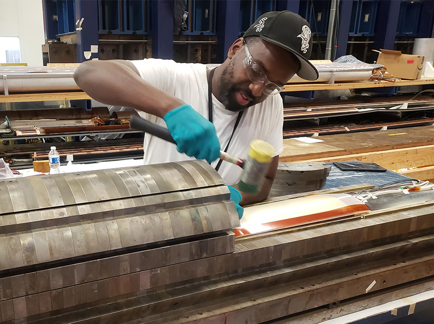 Fermilab technician Martel Walls working on a mirror magnet assembly to test “QCD,” a quench current boosting device.