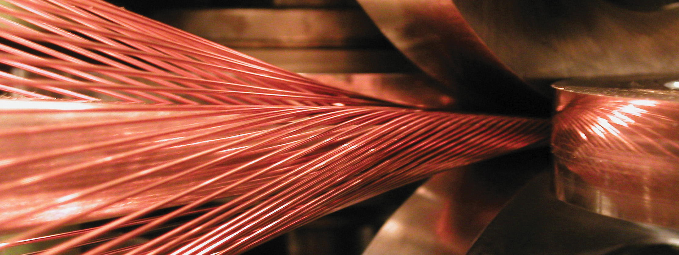 Machining head forms and compresses strands of superconducting wire into a hard flat cable